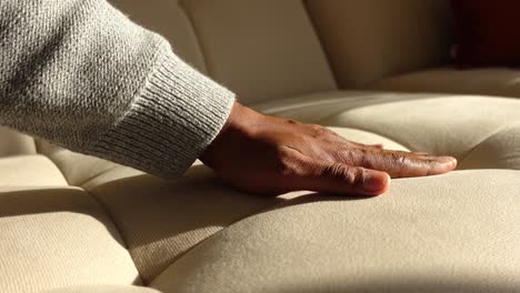person touching a beige sofa