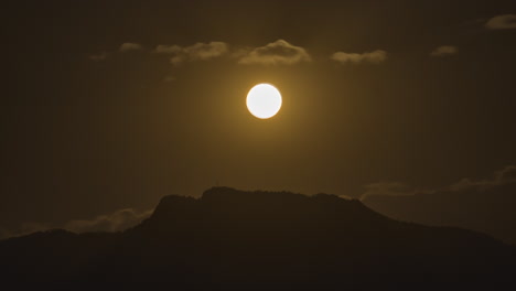 Night-timelapse-of-a-golden-full-moon-rising-over-the-top-of-a-hill