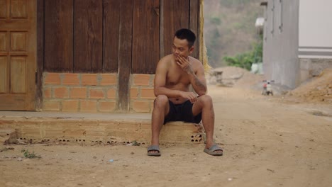 man sitting outdoors in rural area