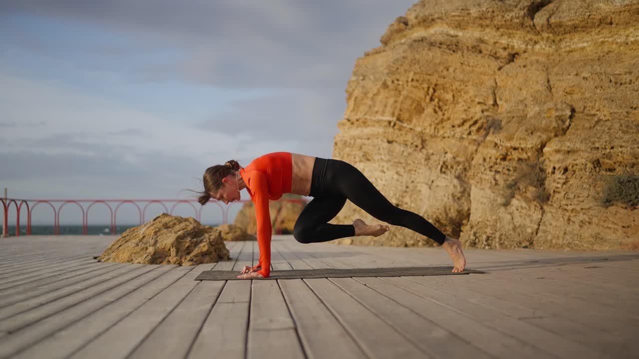 mujer practicando yoga al aire libre junto al océano