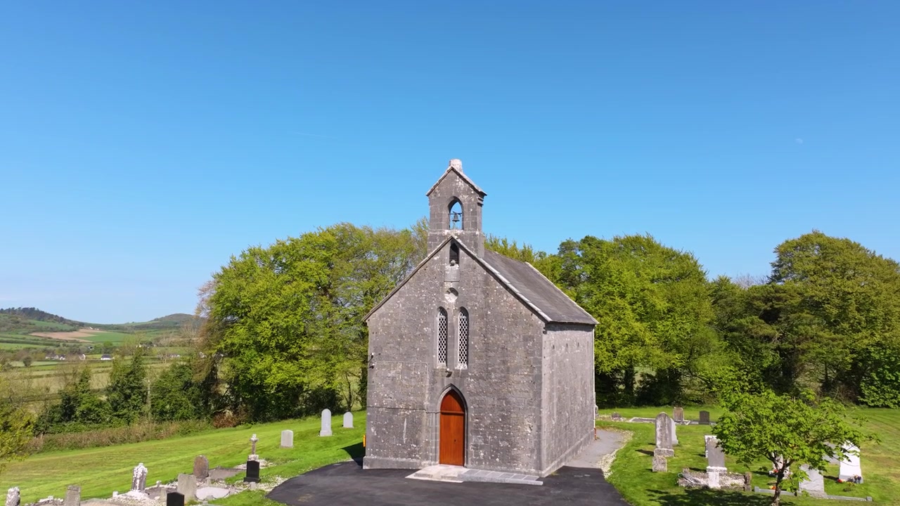 En gammel stenkirke beliggende blandt frodigt grønt med vid udsigt over Laois' landskab. Perfekt til historiske dokumentarer eller rejseindhold.