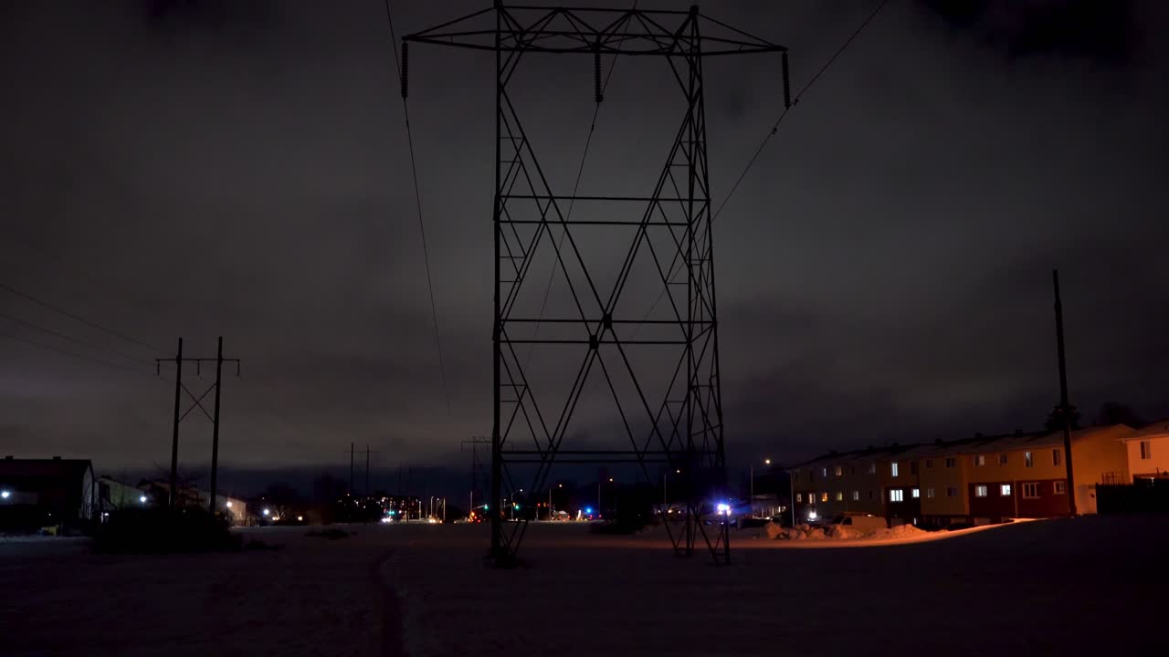 Tall Hydro Towers Running Through a Suburban Area at Night