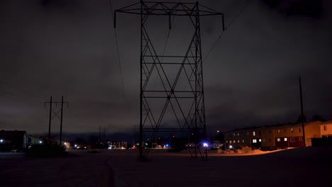 tall hydro towers running through a suburban area at night