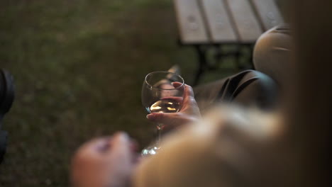 romantic outdoor moment with woman holding wine glass at evening gathering