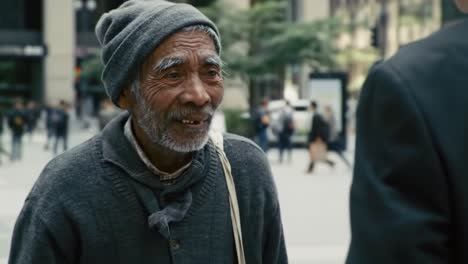 a businessman interacts with an elderly man on a bustling city street. the day is bright, with pedestrians passing by. their exchange highlights a moment of connection amid the urban rush.