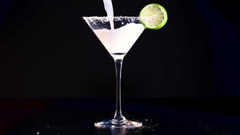 margarita being poured into a glass with lime