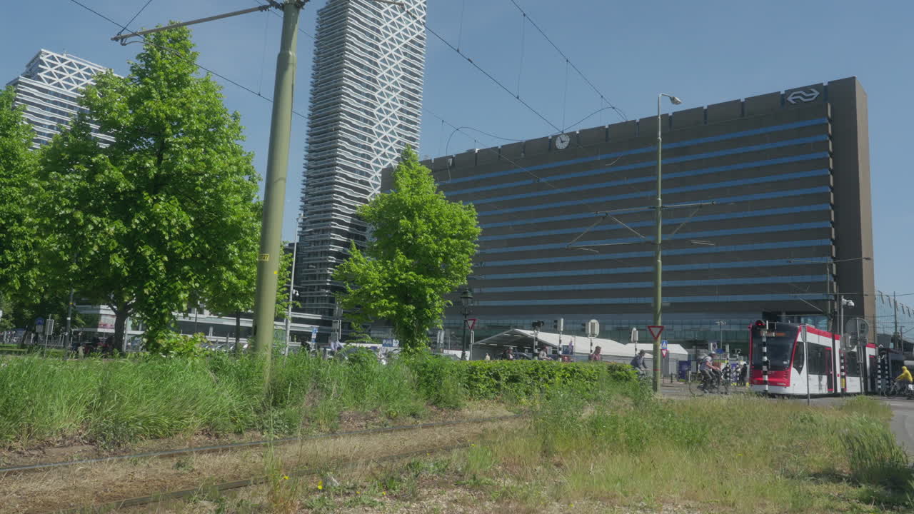 A white tram passes from left to right, going to the central station of The Hague.