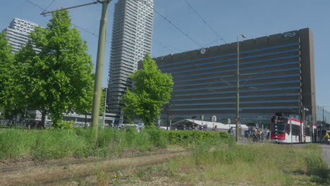 a white tram passes from left to right, going to the central station of the hague.