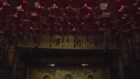 red lanterns on ceiling with yin yang symbol in the middle, buddha statues