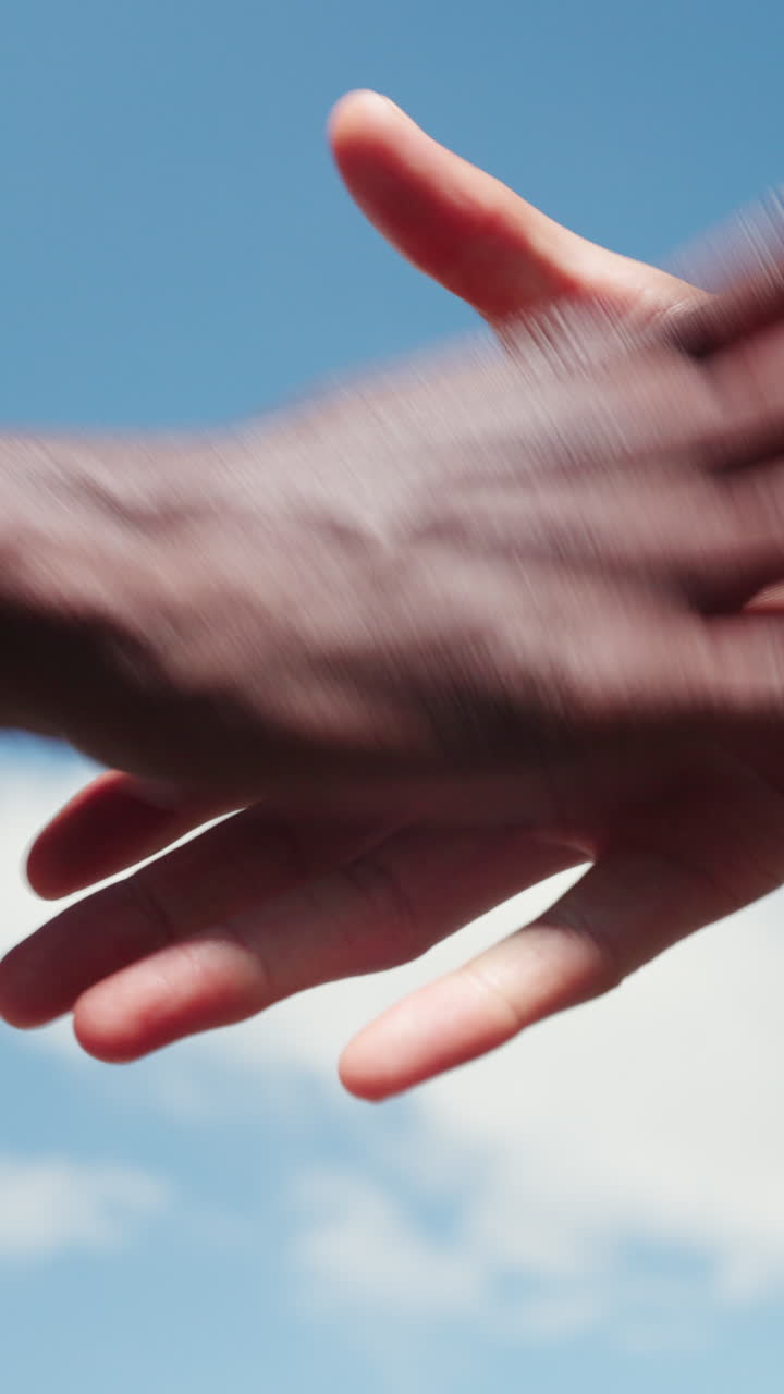 Diverse Hands Fist Bump and Shake Hands Against Blue Sky