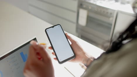 african american woman managing budget on smartphone, focusing on finances, copy space