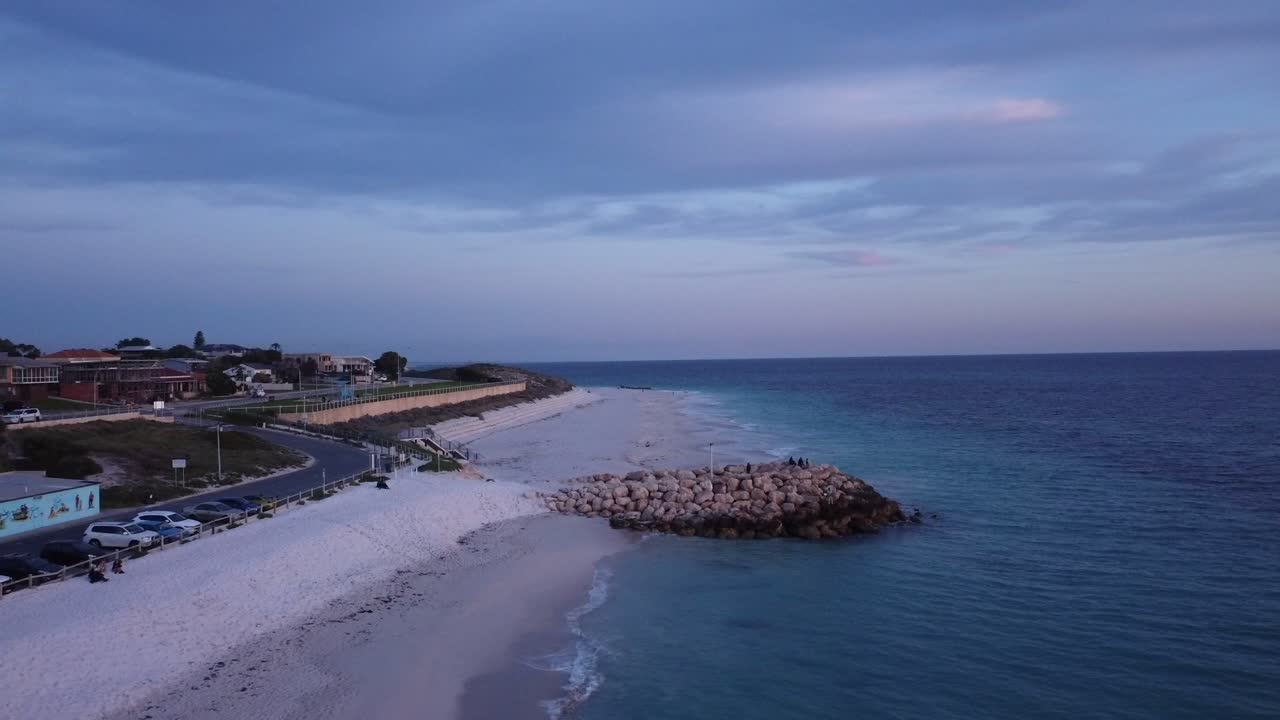 люди наслаждаются видом на океан на пляже квинс-рок, когда заходит солнце, с воздуха