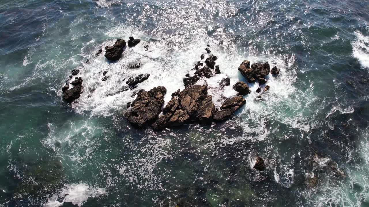 hermosas olas que se rompen en las rocas de un océano azul.