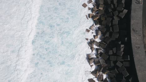 smooth waves crashing on rocks of marina pier, puerto de la cruz, spain