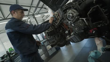 mechanic repairing car engine in auto workshop