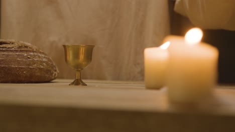 disparo de cerca de un hombre vestido con túnicas que representan la figura de jesucristo bendiciendo el pan y el vino