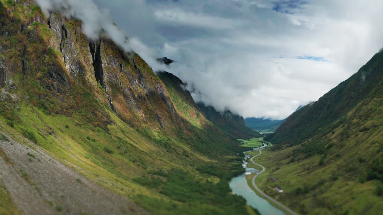 A a wild river flows through the green summer valley between the mountains