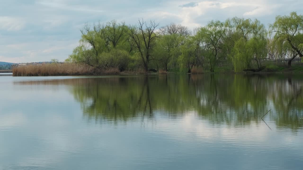 물 속에 구름이 가득한 하늘의 반사와 함께 강이나 호수의 풍경, 저녁이나 아침에 평온한 물의 물결 표면