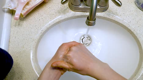 washing hands with soap, lathering up then rinsing and turning taps off