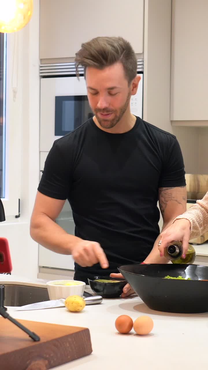 Couple cooking salad in the kitchen and vlogging