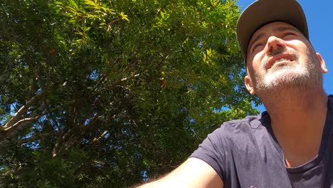 un hombre contento con barba gris anda en bicicleta por un suburbio moderno