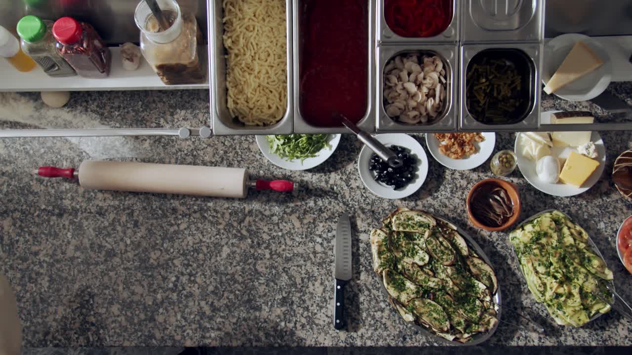 익명의 셰프가 페이스트리를 위해 반죽을 펴고 있습니다.