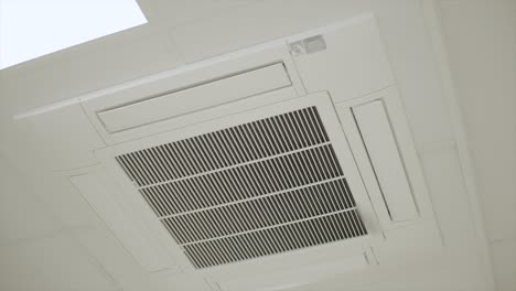 arc shot of central air conditioner fixed in ceiling of business office