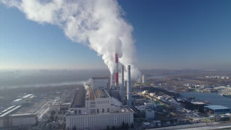 Aerial-establishing-shot-of-a-coal-fired-heating-power-station-with-thick-white-smoke-coming-from-the-smokestacks