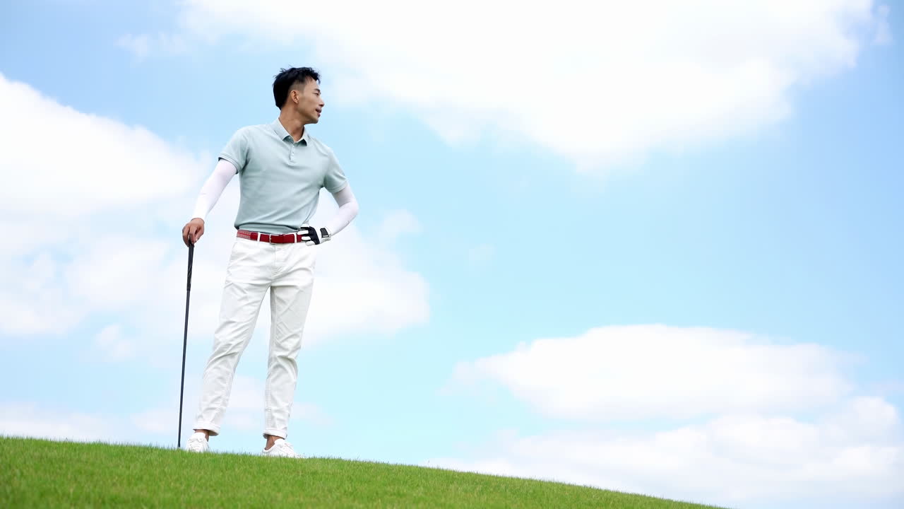Golfer Male Golf Sport Athlete Holding a Golf Club Gazing into the Distance Walking on a field playing golf for fitness, workout or exercise enjoying vacation luxury resort using driver on a sunny day