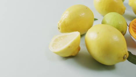 Video-of-fresh-lemons-and-juicer-lying-on-grey-background