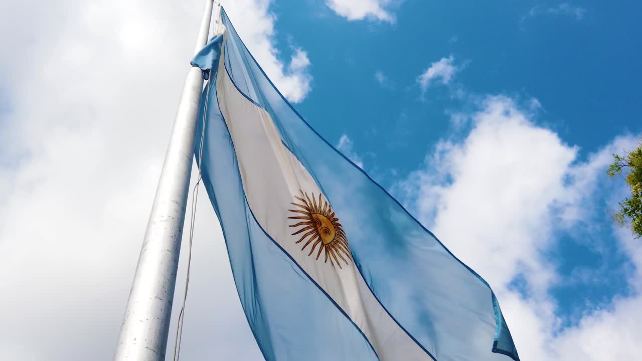 Close Up of Argentina Flag Waving in Wind with Sun Emblem and Sky Reflections