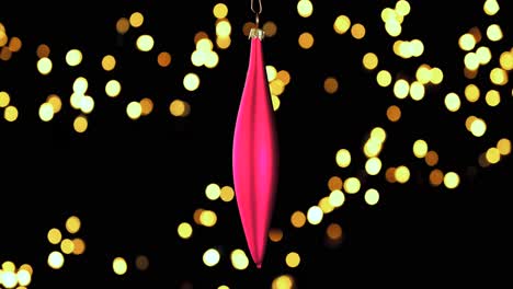 Single-Red-Christmas-Cone-Ornament-Mit-Unscharfen-Lichtern,-Die-Im-Hintergrund-Flackern,-Nahaufnahme