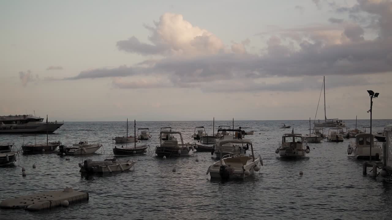 Costiera Amalfitana in Italia, barche ancorate che ondeggiano sulle acque del Mar Mediterraneo all'alba.