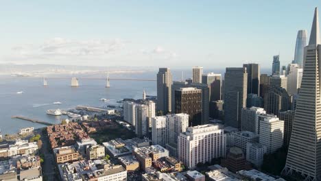 soar above downtown san francisco with this aerial video, featuring the bay bridge and the city's architectural marvels bathed in the warm glow of the setting sun