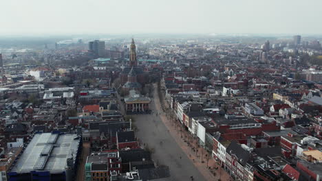 Vista-Aérea-Sobre-El-Paisaje-Urbano-Con-La-Iglesia-Parroquial-Der-Aa-kerk-En-El-Centro-De-Groningen,-Países-Bajos---Disparo-De-Drones