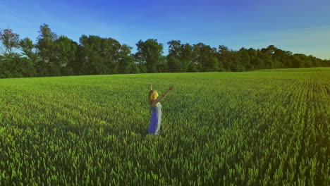 Frau-Steht-Mit-Erhobenen-Händen-Auf-Der-Grünen-Wiese.-Sommerspaziergang-Im-Weizenfeld