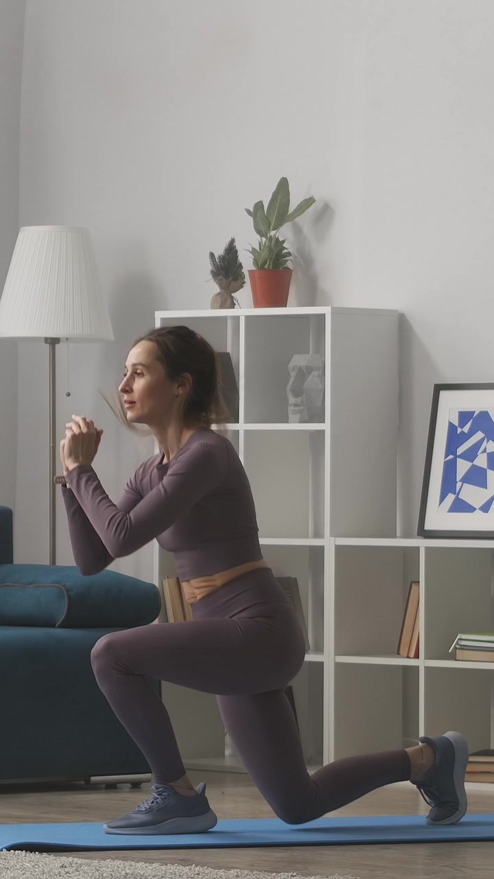 Donna che esegue affondi saltati durante un allenamento a casa.