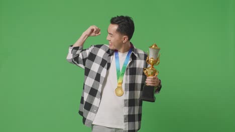hombre celebrando una victoria con un trofeo y una medalla