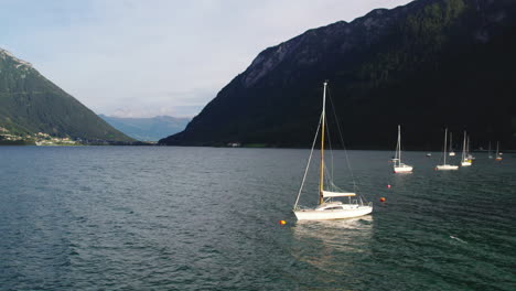 Vista-Aérea-Velero-Flotando-En-El-Idílico-Lago-Achen-En-El-Valle-De-Achen,-Cordillera-Karwendel