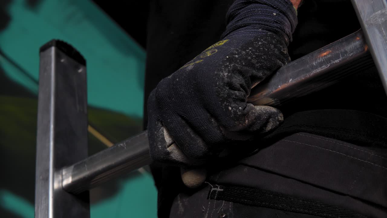 cámara lenta: el hombre está dibujando y pintando con pintura en aerosol en la pared