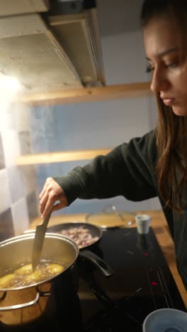 mujer cocinando patatas en la cocina