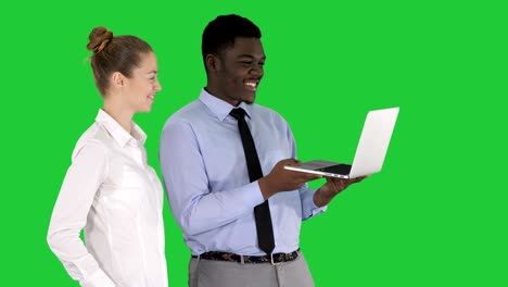 satisfied of their work man and woman looking in the laptop on a green screen, chroma key