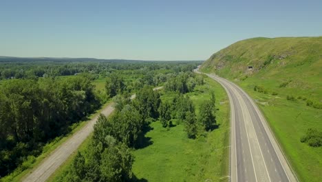 aerial flying vertically upward above the highway in mountainous area