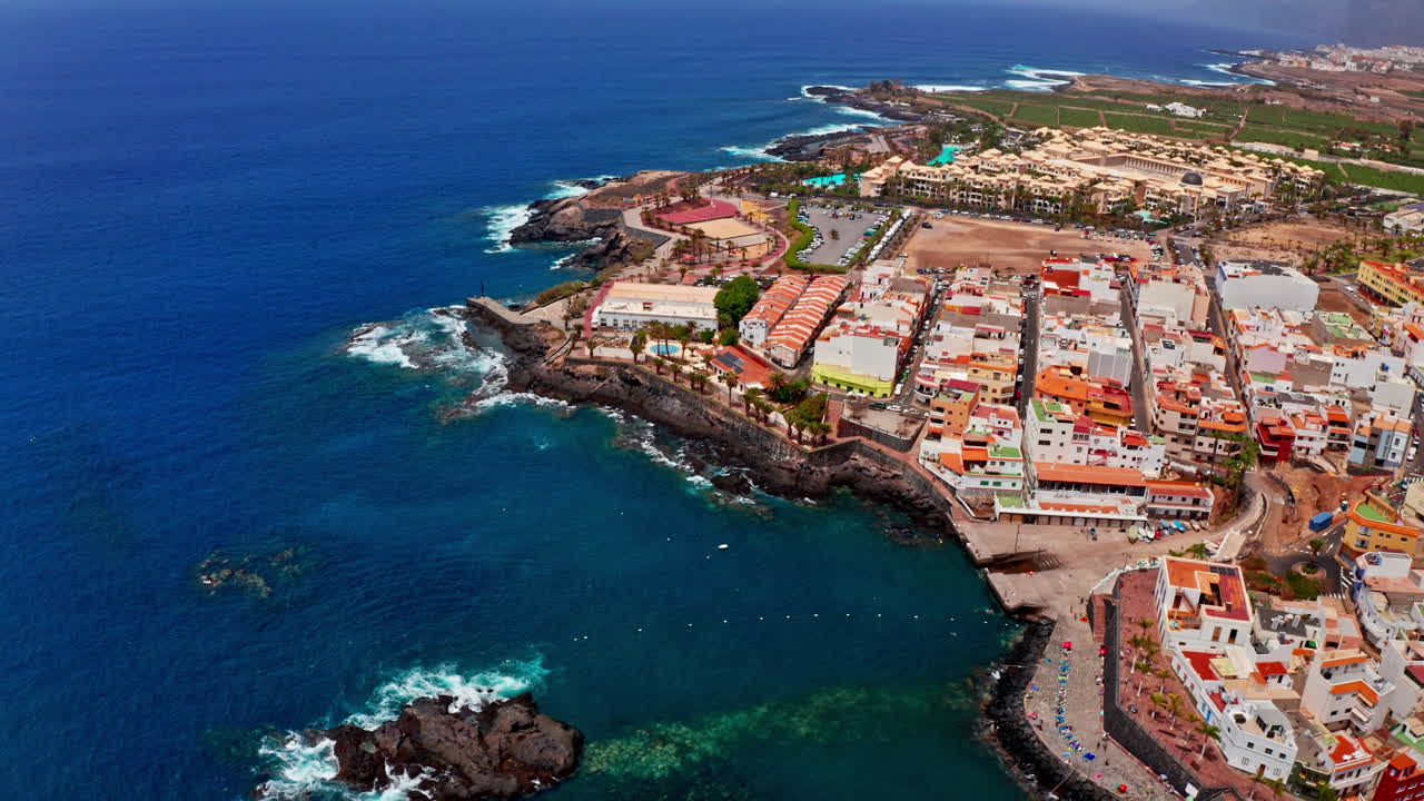 테네리페, 카나리아 제도, 스페인의 아름다운 화산 바위 해안에서 공중 드론 촬영. 해변 리조트, 푸른 바다 및 지역 마을의 높은 전망. 여름 휴가 목적지.