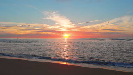 Una-Marea-Baja-Tranquila-En-La-Playa-Cerca-De-La-Barrera-De-Marejada-En-El-Suroeste-De-Los-Países-Bajos,-Durante-La-Puesta-De-Sol