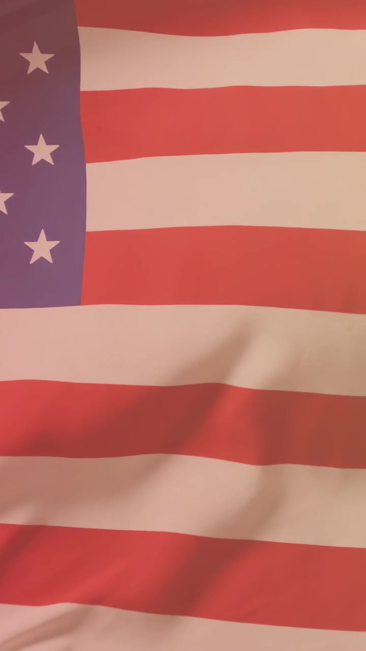 วิดีโอแนวตั้ง: นักกีฬาชายเคลื่อนไหวอยู่หลังธงชาติสหรัฐฯ ทำให้เกิดรอยพับเผยให้เห็นเสื้อกีฬาหมายเลข 3 สำหรับการแข่งขัน