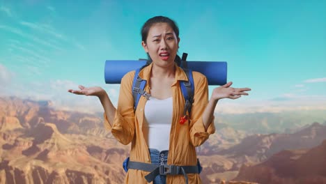 Puzzled Asian Female Hiker With Mountaineering Backpack Making Gestures Doubtfully And Saying Why While Traveling At The Top Of Mountain