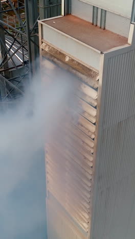 thick smoke from factory. chemical plant outdoors. harmful manufacturing releases dangerous vapor into the air. pollution of the environment. aerial view. vertical video