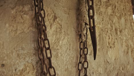 rusty chains hanging against an old stone wall, showcasing aged metal textures