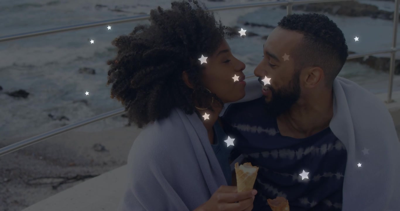 Animation of glowing star icons over african american couple embracing each other at the beach
